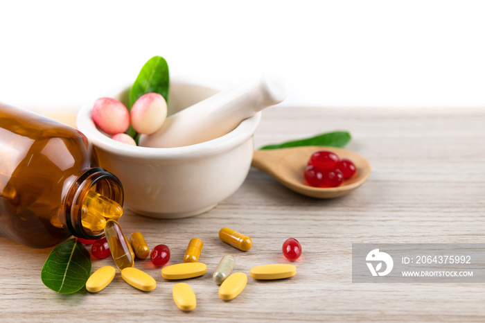 Alternative herbal medicine, vitamin and supplements from natural, pills and capsules in spoon on wo