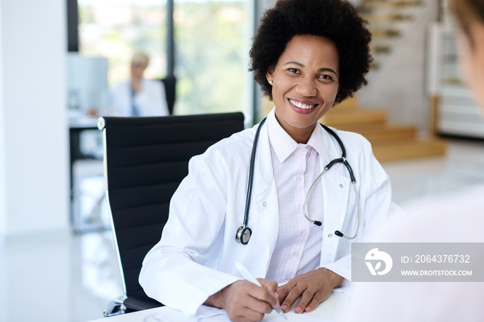 Happy African American female doctor working at medical clinic.