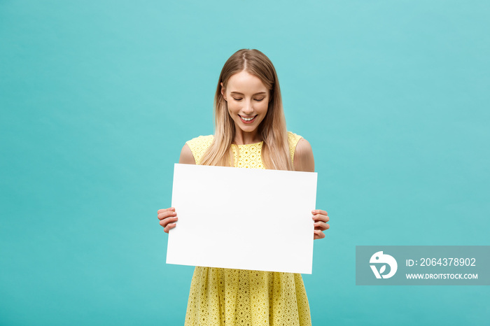 Beautiful woman holding a blank billboard isolated on blue background