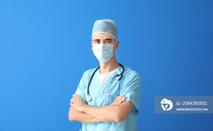 Male doctor in medical mask on color background