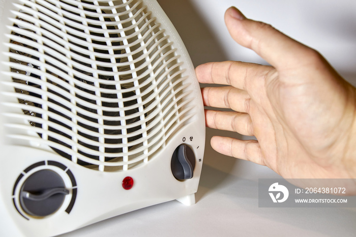 人员打开风扇加热器为房间供暖。便携式、自主式、电动空间供暖。
