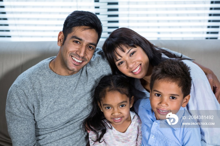 Happy young family posing together on the sofa