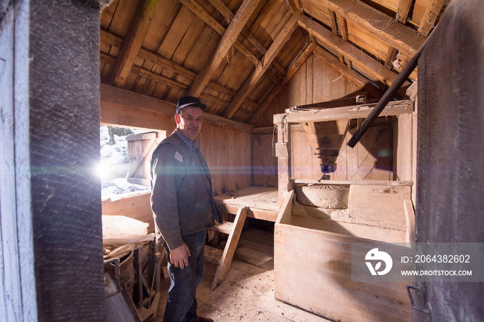 portrait of a miller in retro wooden watermill