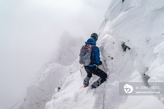 一名登山运动员在冬季极端条件下攀登高山山脊。冒险攀登高山i峰