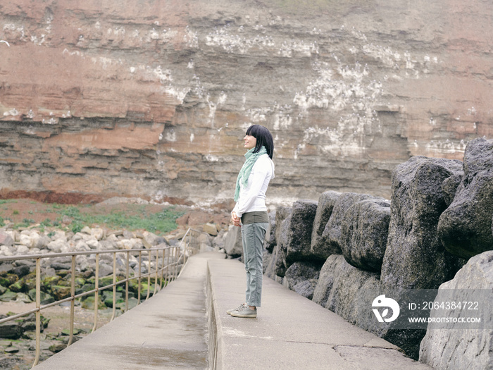 英国，一名女子站在岩石景观中的人行道上