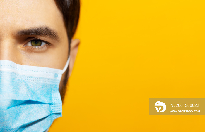 男性面部特写，橙色背景上戴着医用流感口罩，带复制水疗中心