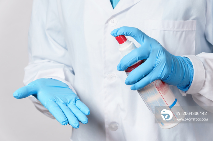 Doctor makes an additional disinfection of the gloves with a alcohol spray