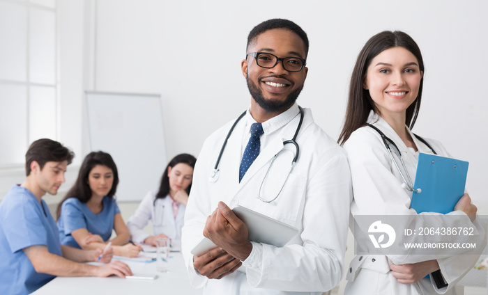 Two Doctors In White Coats Posing To Camera At Conference