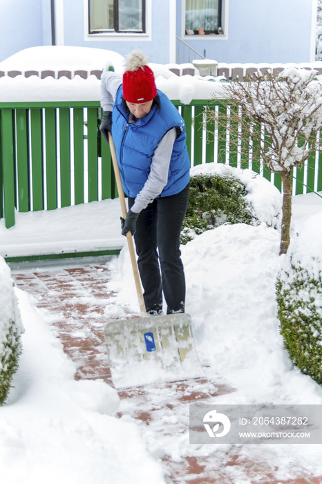 Frau beim Schnee schaufeln