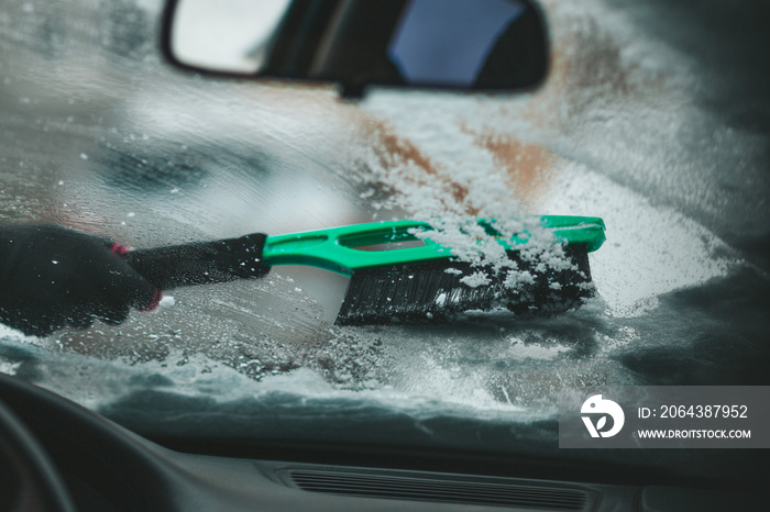 Car windshield icy. Brush snow off the vehicle.