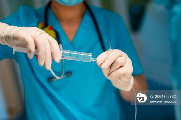 Doctor adjusts medical dropper with medicine in surgery room. Selective focus on hands.