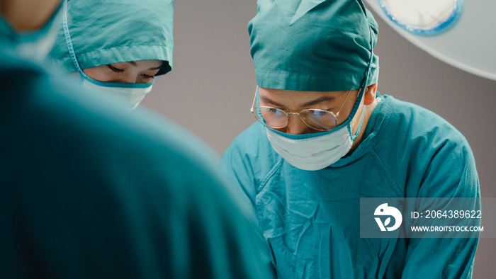 年轻的亚洲助理和护士在医院手术室为患者进行侵入性手术。