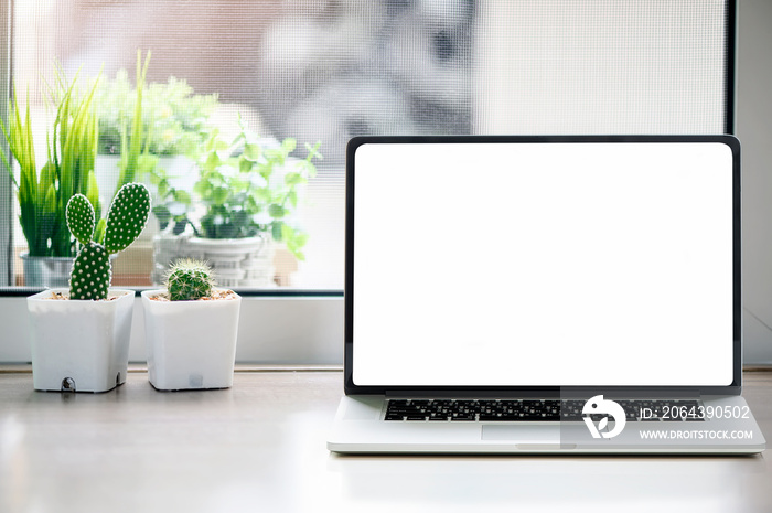 Mockup white blank screen laptop with cactuses flower on wooden table.