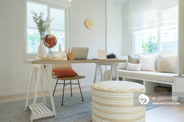 开放式工作空间的时尚波西米亚风格家居内部，配有木制桌子、椅子、灯、笔记本电脑和白色sh