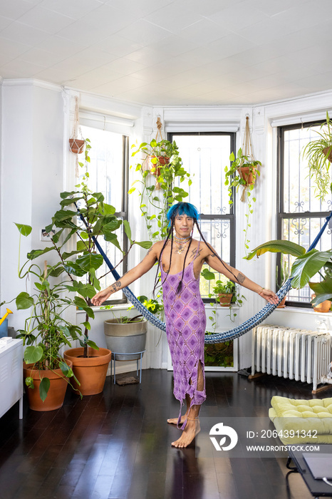 indigenous non-binary artist dancing at home surrounded by house plants