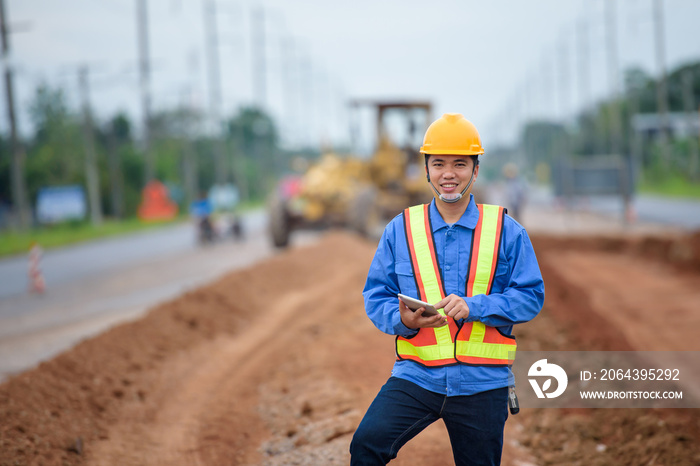 亚洲年轻工程师监督道路施工，检查施工现场道路施工