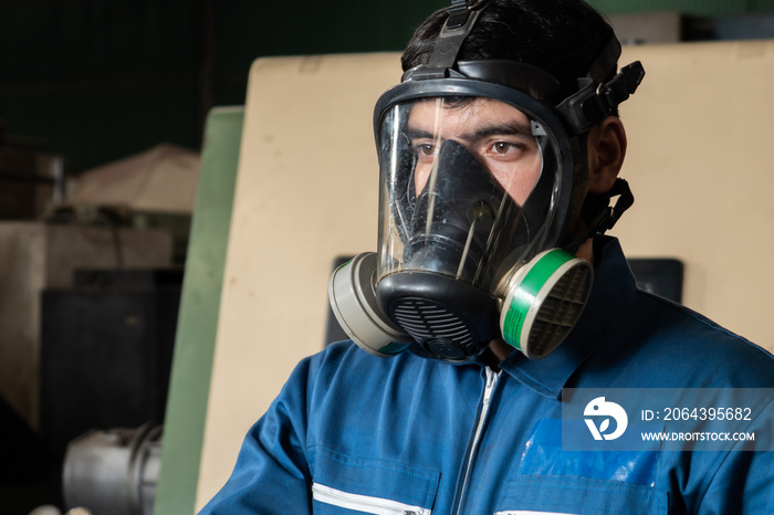 Skillful worker wears gas mask in the factory . Industrial people and manufacturing labor concept .