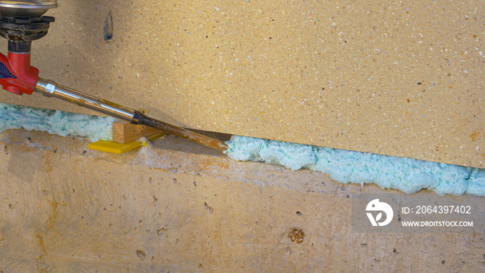 CLOSE UP: Contractor fills up a crease in the wall with polyurethane foam.