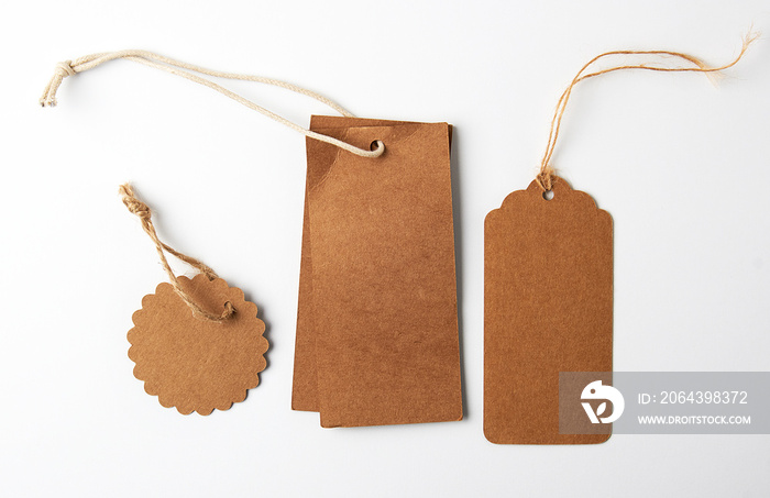 various brown paper tags with ropes on white background