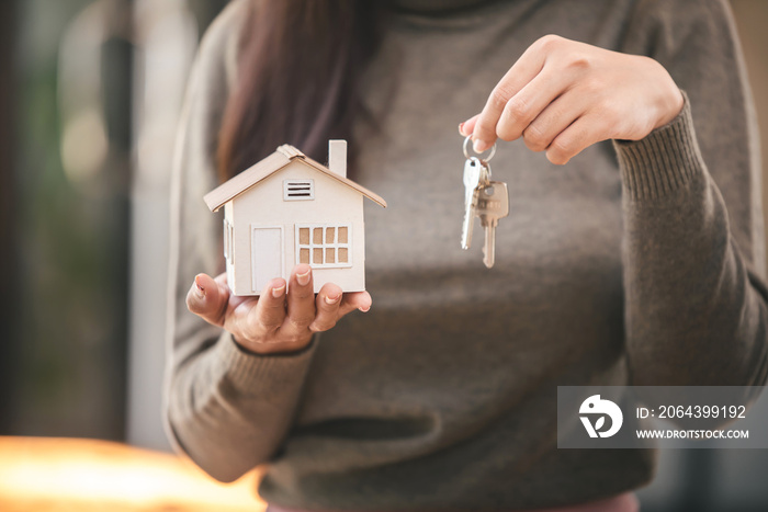 Real estate agent with house plans and keys in hand.