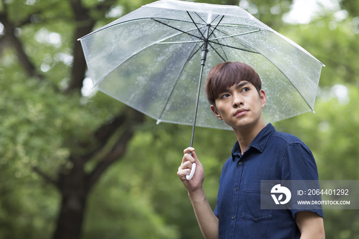 年轻男子打着雨伞