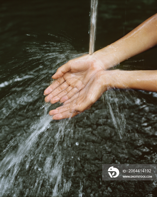 Close up of woman hands under stream of water