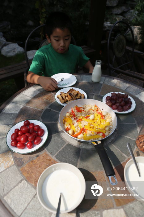 小男孩在庭院里吃早餐