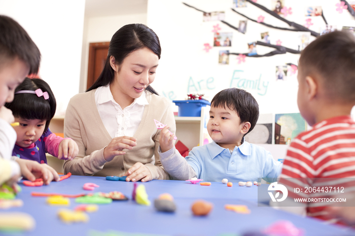 幼儿园老师教孩子们捏橡皮泥