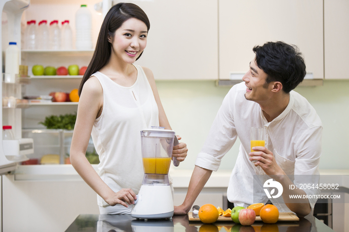 年轻女士为丈夫榨橙汁