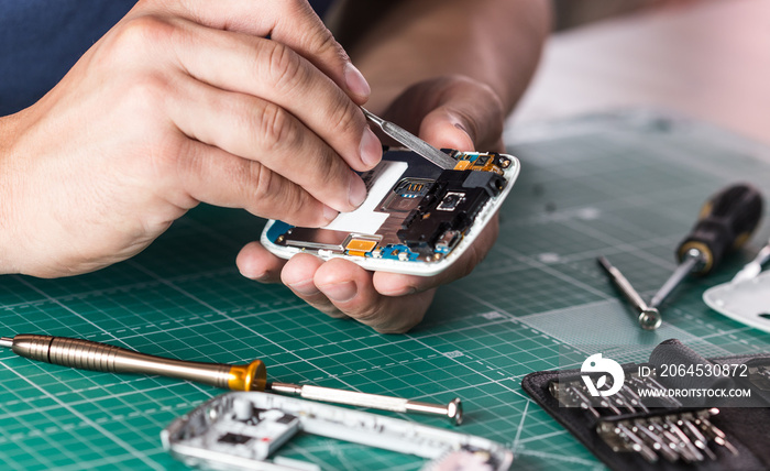 Man repairing broken smartphone, close up photo