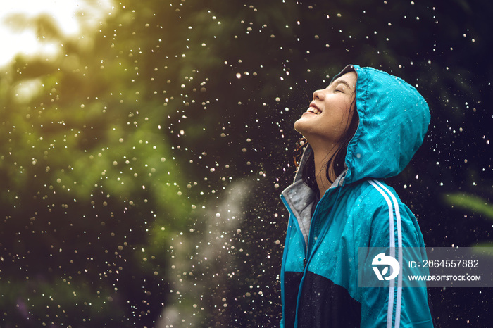 在户外穿着雨衣的亚洲妇女。她很快乐。