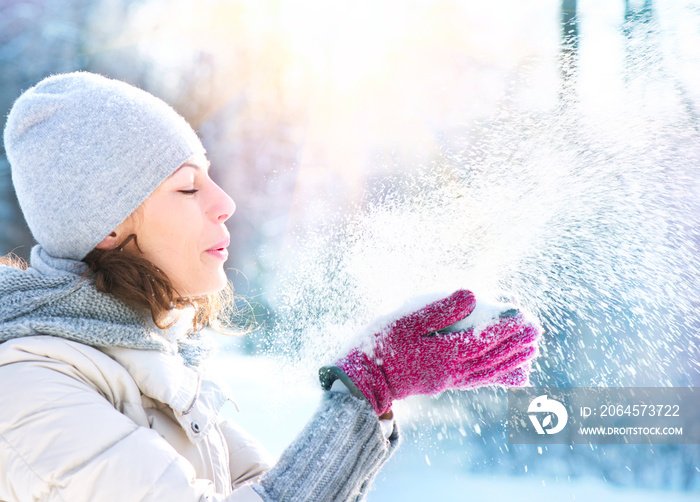 美丽的冬天女人在室外吹雪