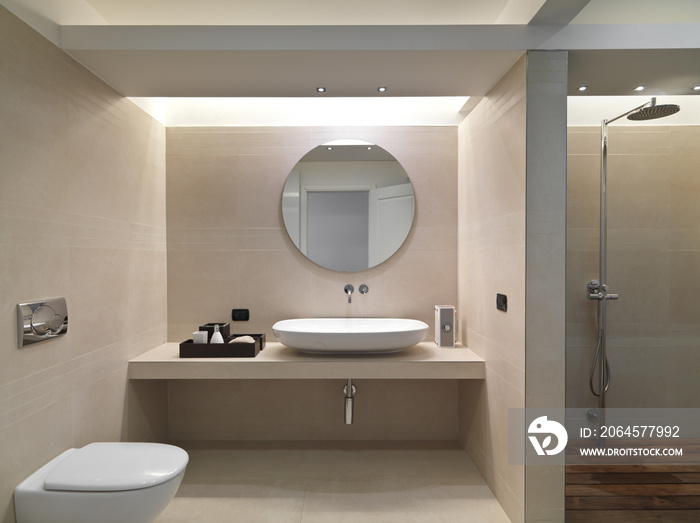 Bagno moderno con rivestimento in marmo e lavabo in ceramica bia