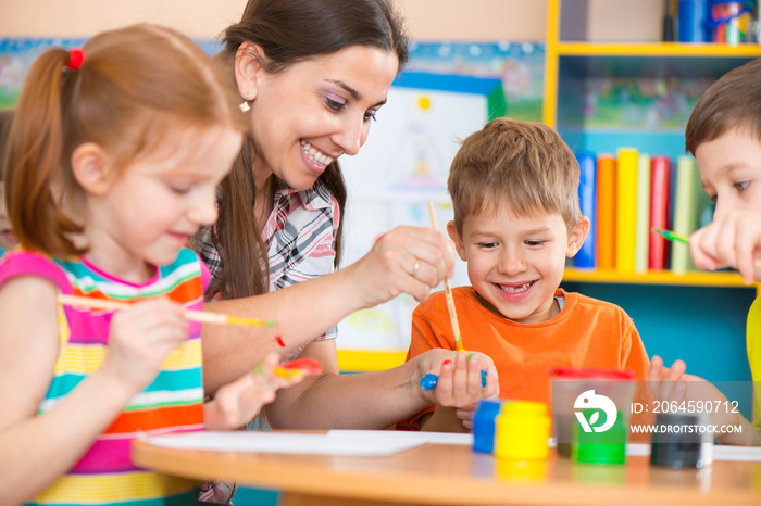 Cute children drawing with teacher at preschool class