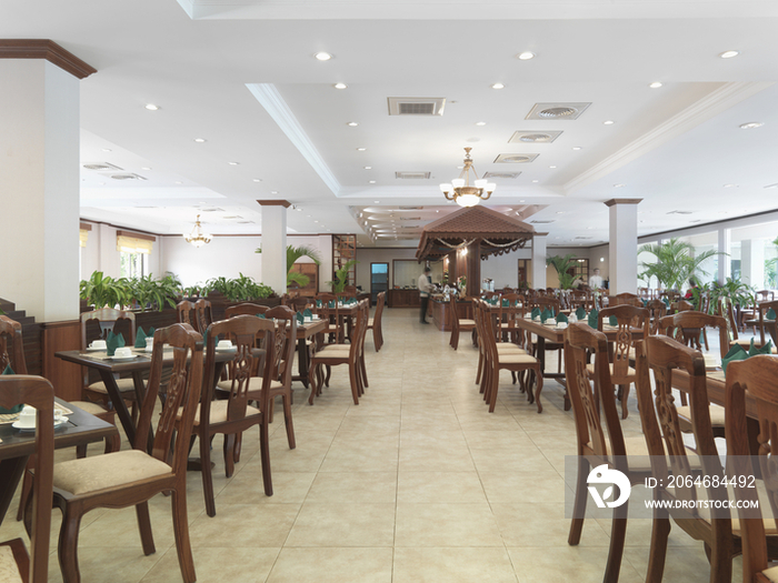 Large group of wooden chairs arranged in restaurant