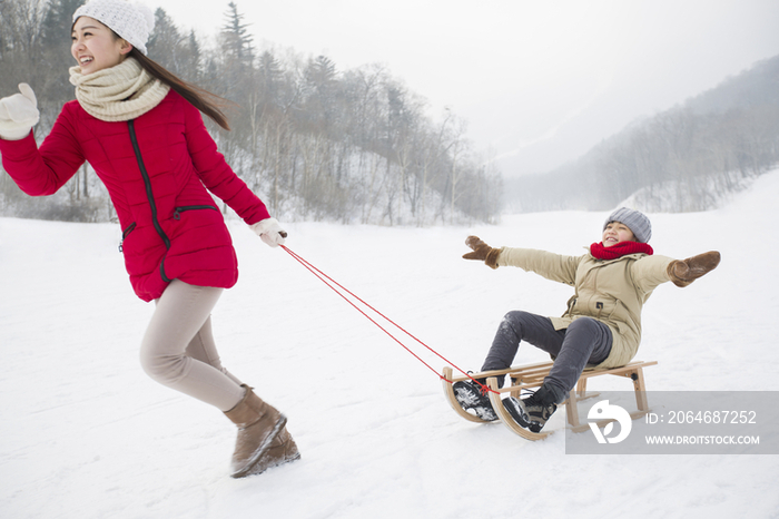 母子俩在雪地上玩雪橇