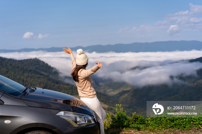 年轻的女性旅行者开车在山上观看美丽的雾海，开车旅行