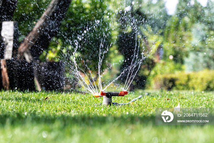 草坪上安装了不同旋转洒水器的景观自动花园浇水系统。兰