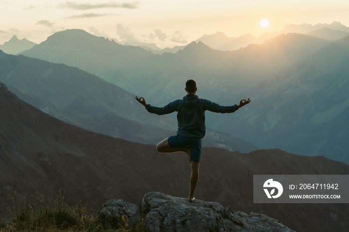 年轻人在练习瑜伽。在瑞士阿尔卑斯山，他正在伸展身体，日落时感到放松