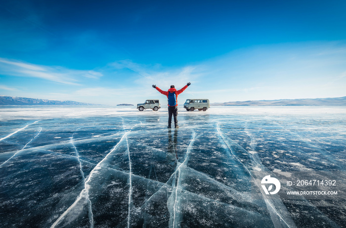 Traveler man wear red clothes and raising arm standing on natural breaking ice in frozen water at La