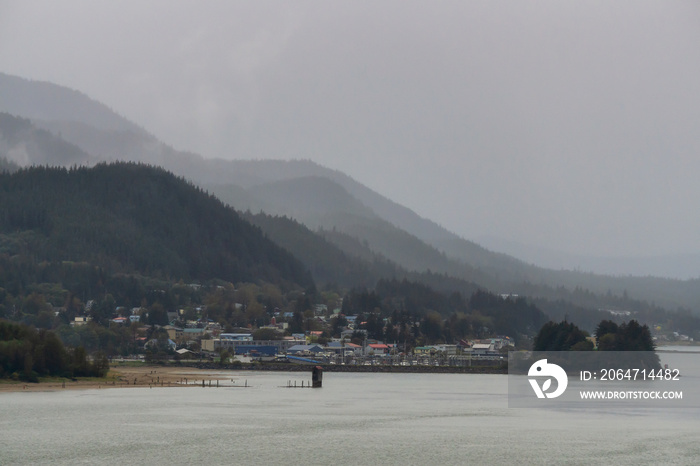 Beautiful view of a small town, Juneau, during a cloudy morning with mountains in the background. Ta