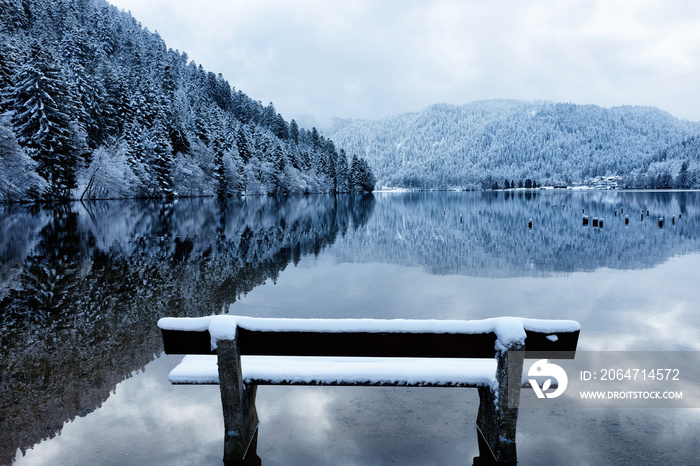 Bench by the Longemer Lake in the Vosges mountains, Xonrupt-Longemer, Lorraine, France. Winter lands