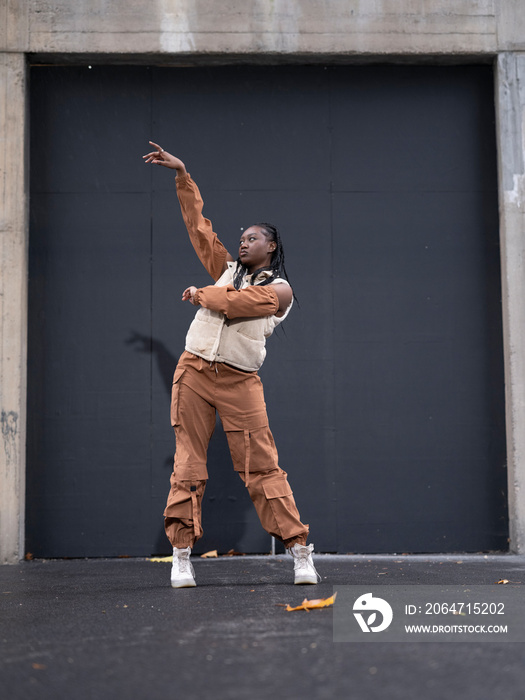 Young woman in sports clothing dancing in city