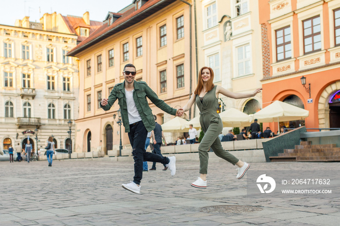 young beautiful couple of tourists stand in the square in the city of Krakow in Poland