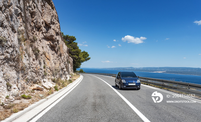 Car rushes along the road to the sea. Car highway along the coast of the Adriatic Sea, in Brela, Cro