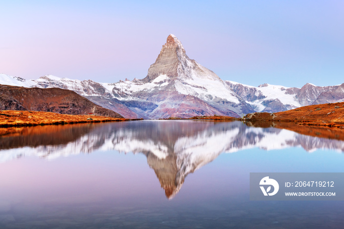 Picturesque landscape with colorful sunrise on Stellisee lake. Snowy Matterhorn Cervino peak with re