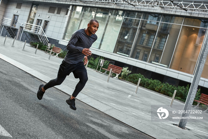 Confident runner. Full length portrait of athletic african man in sportswear running with very fast 