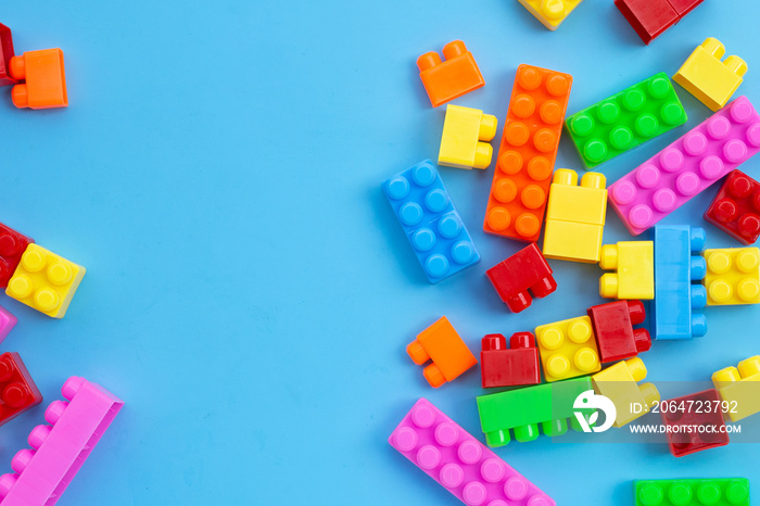 Plastic building blocks on blue background.