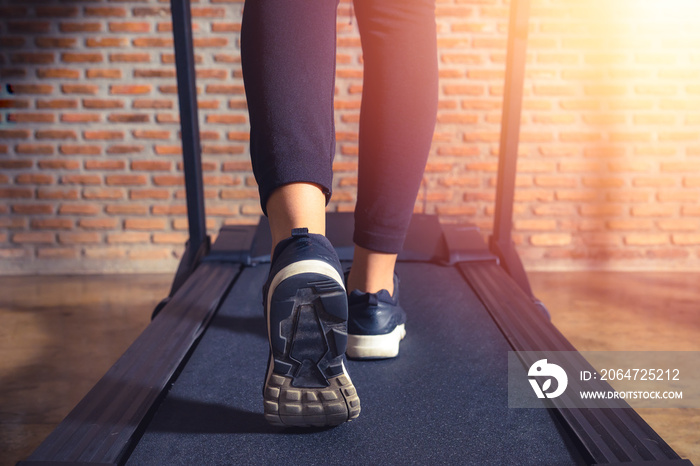 腿部特写运动员，在健身房跑步机上跑步的女人。锻炼和阳光效果，fi