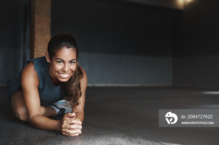 Attractive hispanic woman stretching body, sit with crossed leg, half-plank, doing fitness exercises